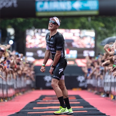 Braden Currie at the finish line of Ironman